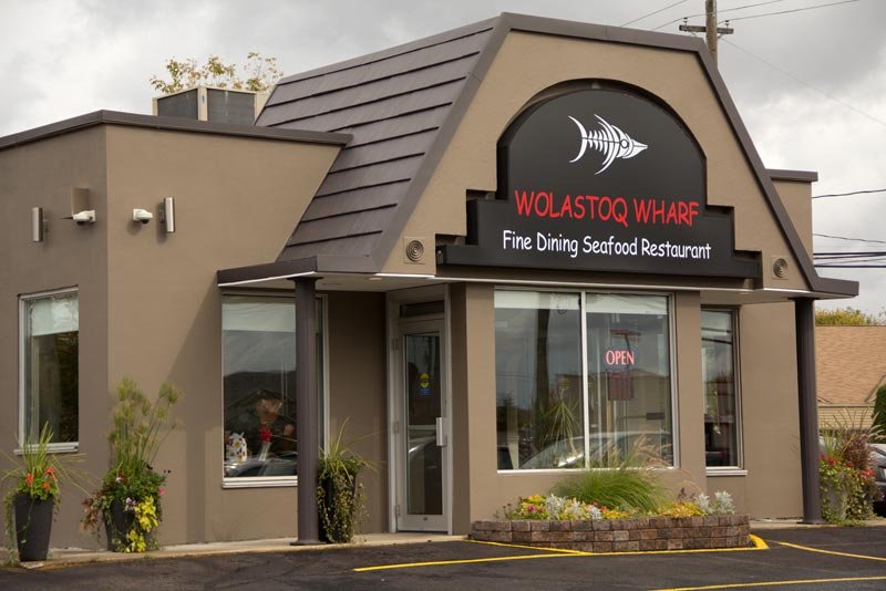 a white plate topped with a salad covered in shrimp